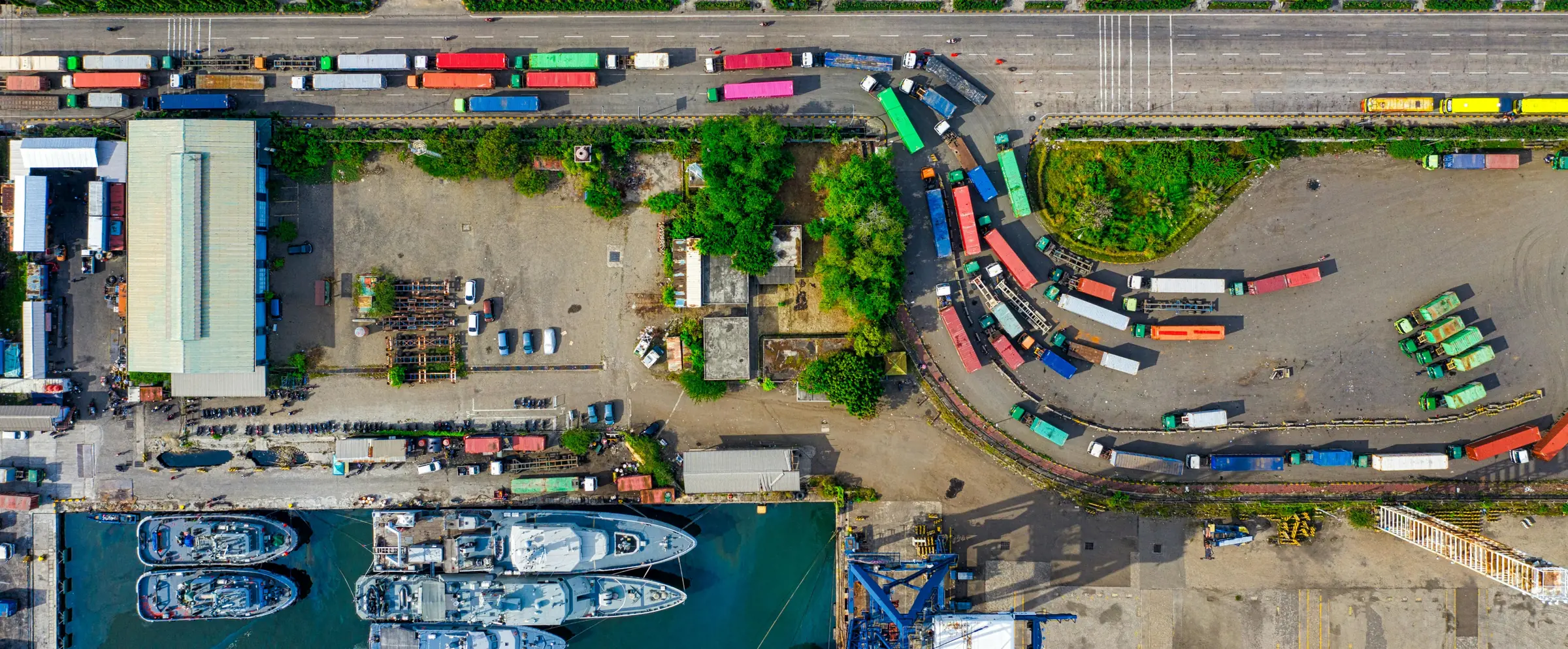 Aerial view of a port terminal with container trucks queued along the yard